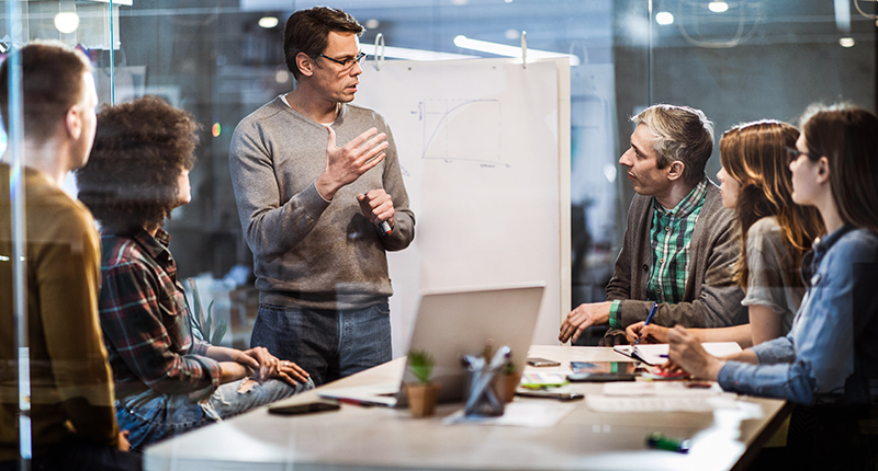 Manager presenting to his team in office setting