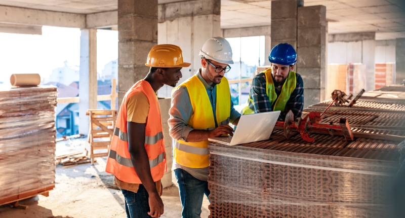 construction workers using project management software on a job site