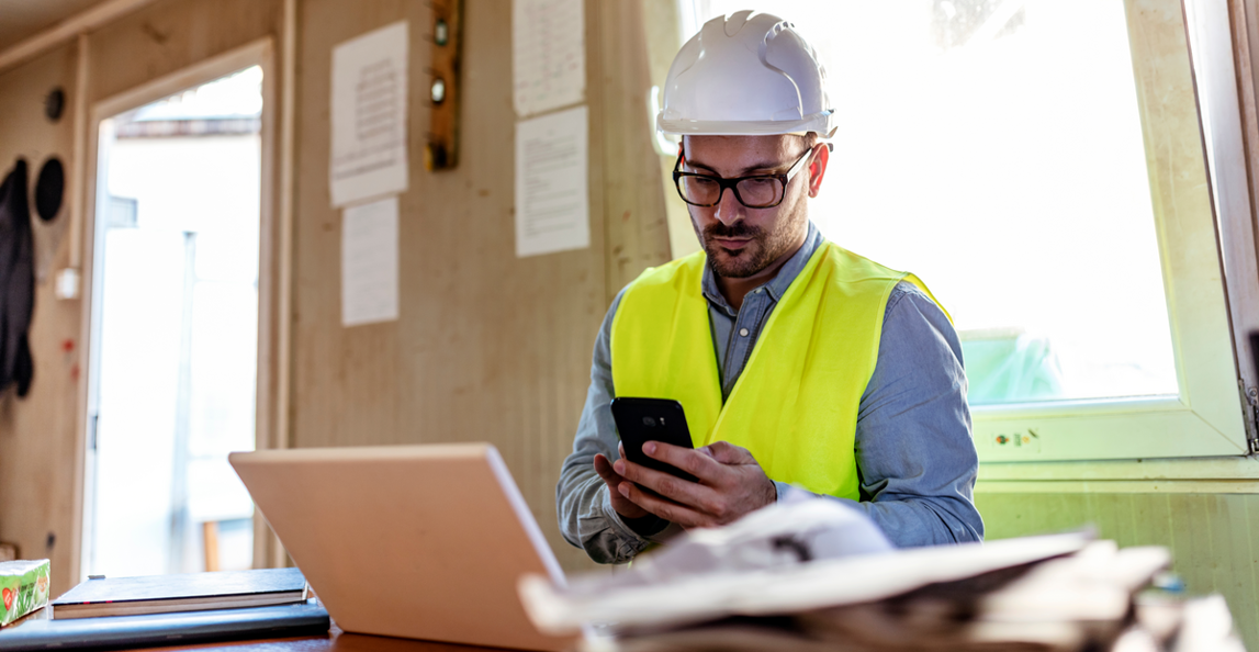 architect working on mobile device at construction site office