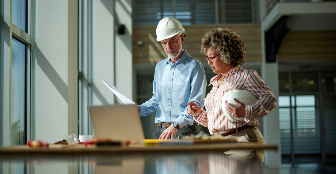 Architects reviewing project documents and financials on a laptop
