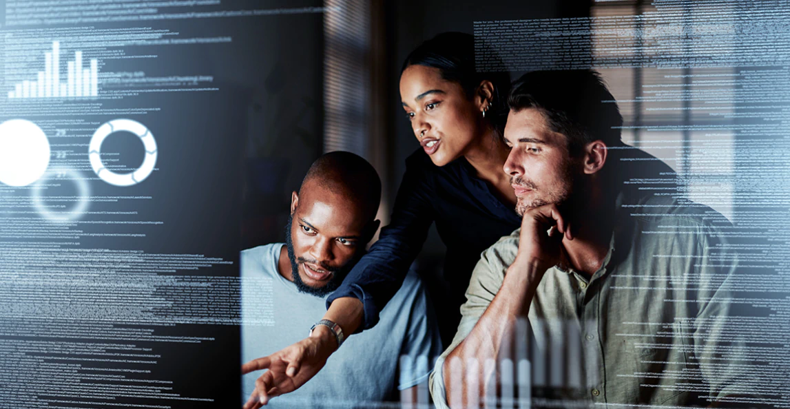 Three colleagues analyzing data dashboards and code on a computer screen