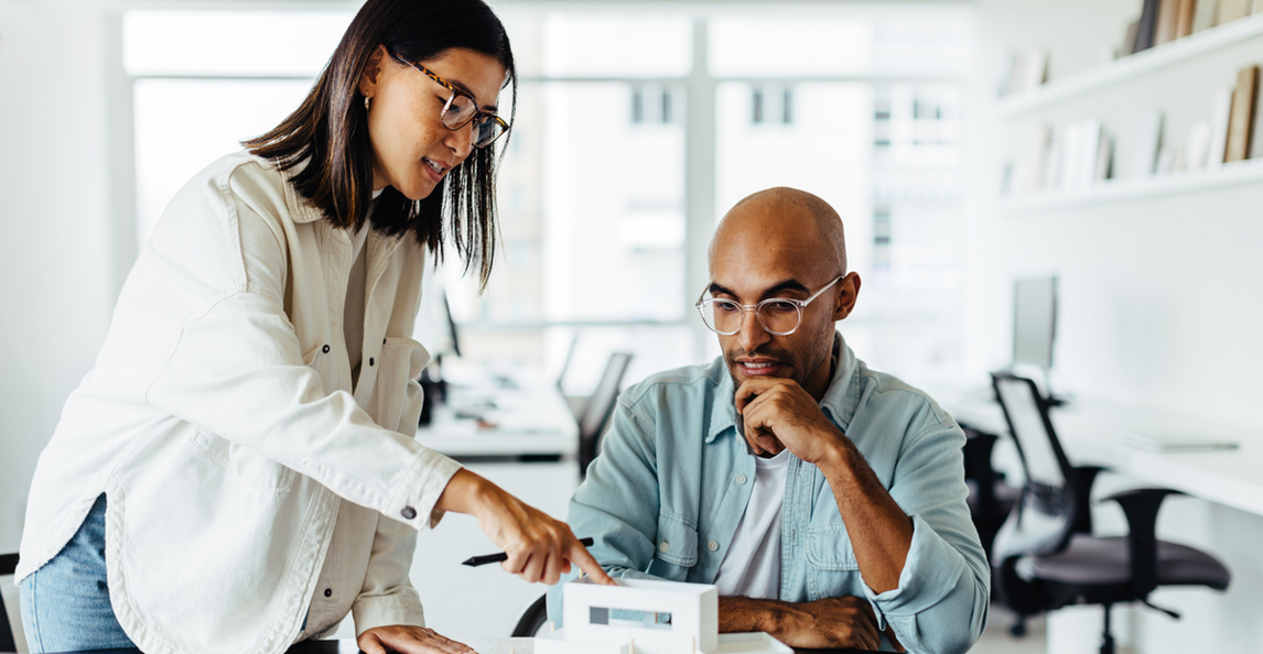 Two business professionals collaborating over a project in a modern office