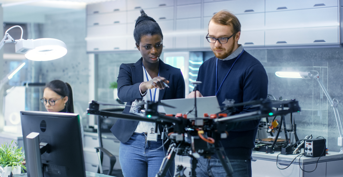 Two engineers collaborating on a drone project in a modern tech laboratory