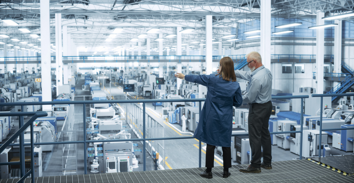 Engineers overseeing automated manufacturing production floor from a mezzanine platform