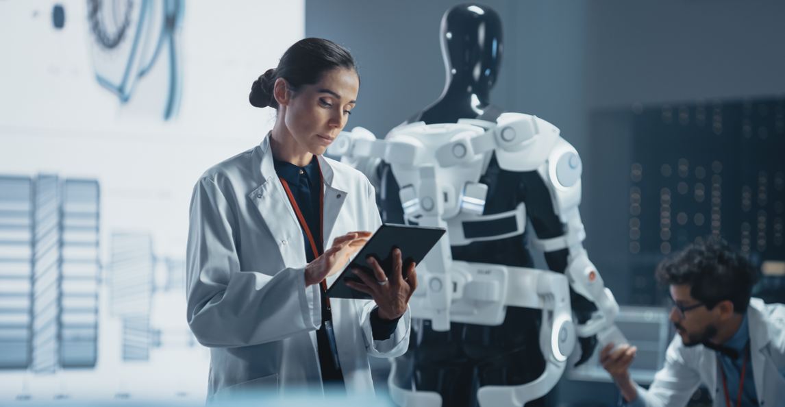 Engineer in lab coat operating a tablet next to a humanoid robot in a research facility