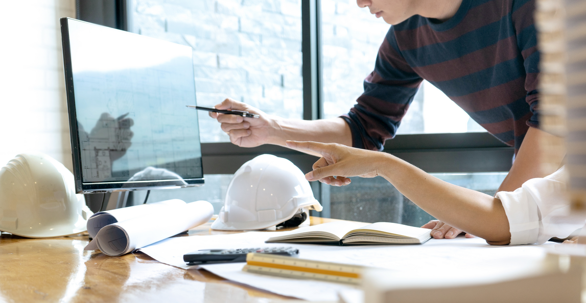 two architects looking at plans on a computer screen