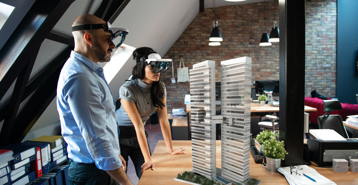 two professionals using augmented reality headsets to visualize an architectural model in a modern office