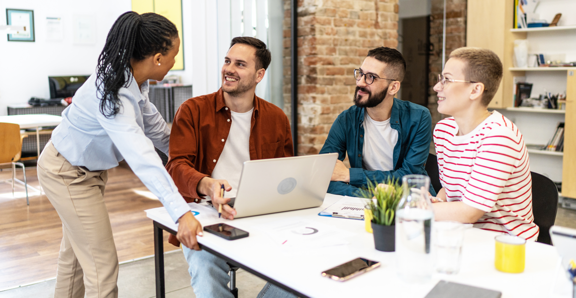 Diverse team of professionals collaborating on project financials in a modern office
