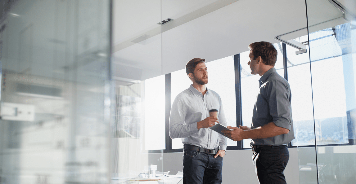 Two colleagues discussing work in a modern office