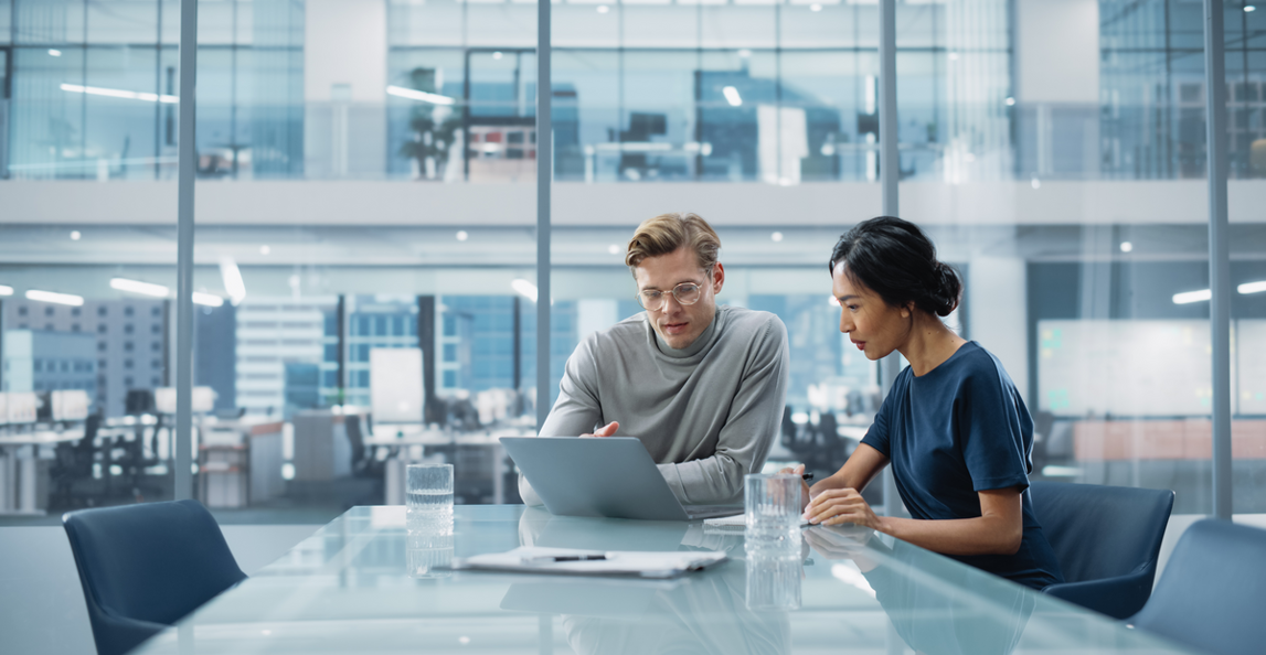 two professionals working on a business proposal in an office