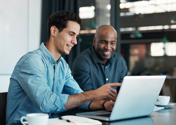 Two people discussing information displayed on a laptop