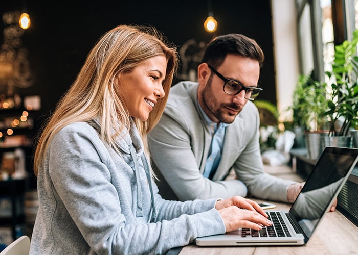 Two Business Professionals Collaborating on Project Work Using Laptop in Office