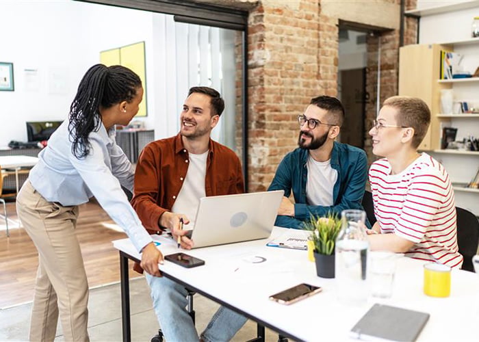 cheerful team of coworkers making great business discussion in modern office