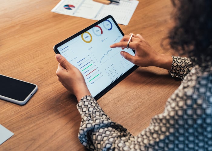 Business Professional Analyzing KPI Dashboard and Performance Metrics on Tablet