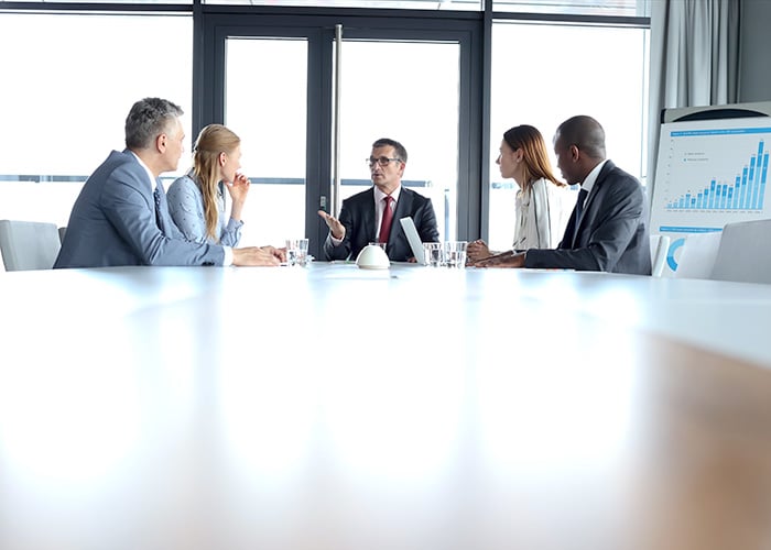 Diverse Executive Team Discussing Business Performance and Growth Strategy in Boardroom