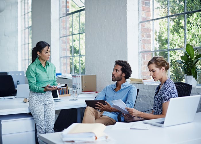 Three business people discussing a project