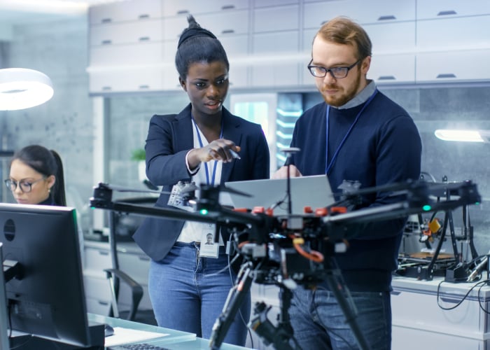Engineers working on a drone in a lab