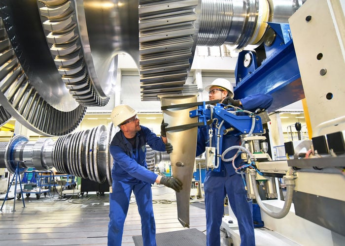 Workers assembling and constructing gas turbine