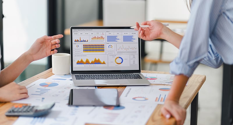 People discussing data on a laptop