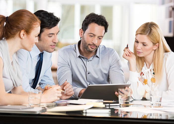 Business Professionals Collaborating on Tablet During Corporate Strategy Meeting