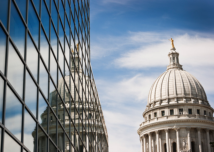 Reflection of capital building on outside of office building