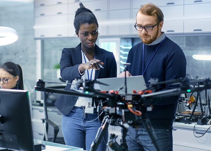 Two professional engineers working on a drone project with the help of laptop