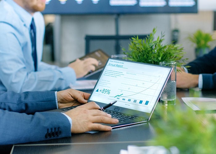 Close-up laptop showing graphs during a meeting in a conference room