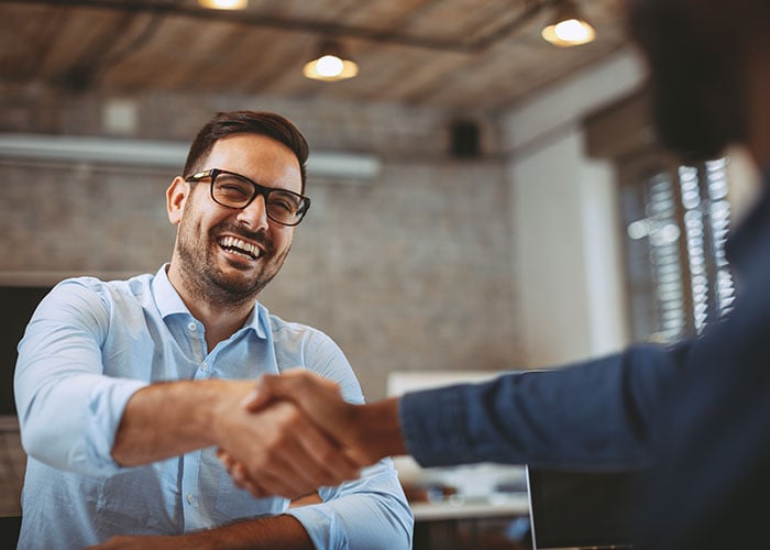 Happy man shaking hands when closing a deal