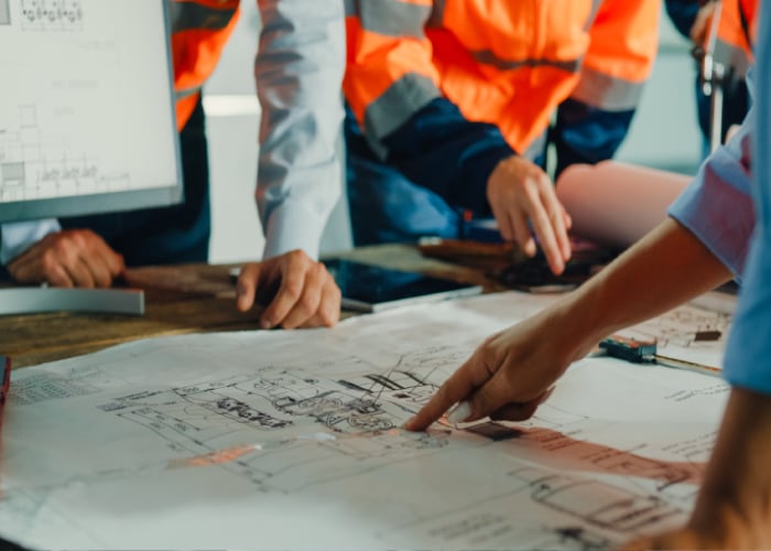 Engineers reviewing machinery blueprints