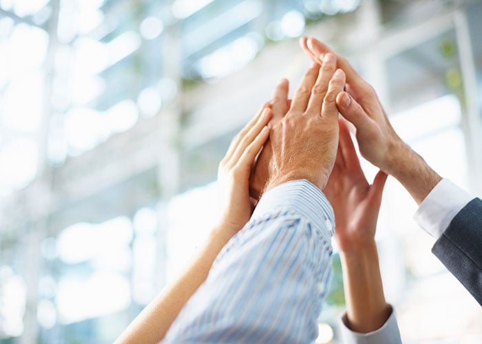 Diverse Business Team Celebrating Project Success with Group High Five in Corporate Office