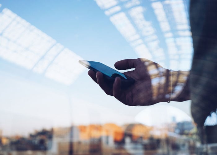 Double exposure of person using smart phone