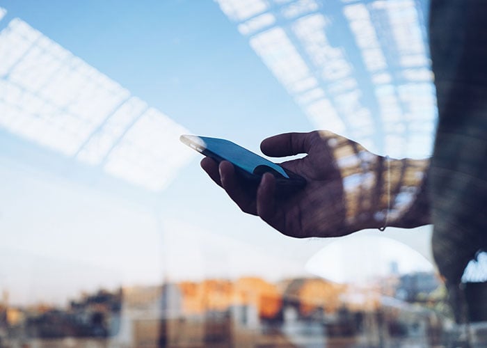Double exposure of person using smart phone
