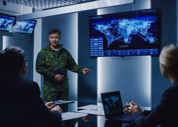 Military officer presenting in a conference room.