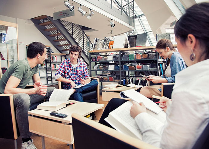 Group of Students Engaged in Collaborative Study Session in Modern Library