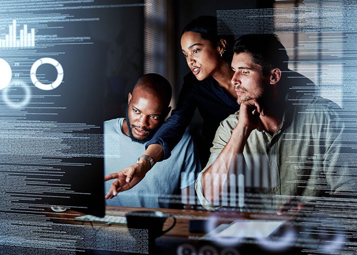 Group of programmers working together on a computer code
