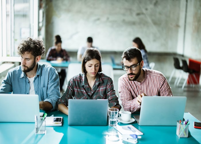 Small business team collaborating on laptops in a modern office