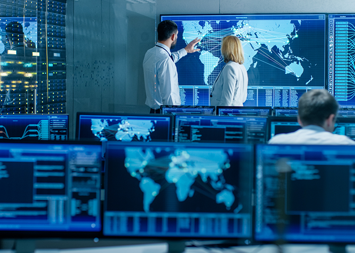 Two senior operators working on a big interactive map in a system monitoring room