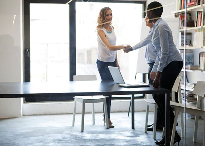 Job Candidate Greeting Hiring Manager with Handshake at Professional Interview