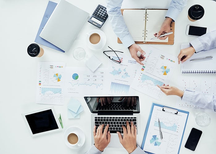 Reviewing and analyzing data and trends at a conference table