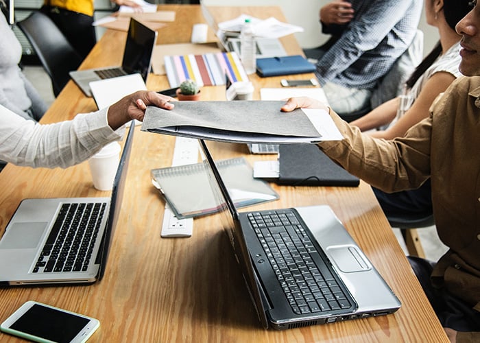 Business Professionals Exchanging Project Documents and Reports in Collaborative Office Environment