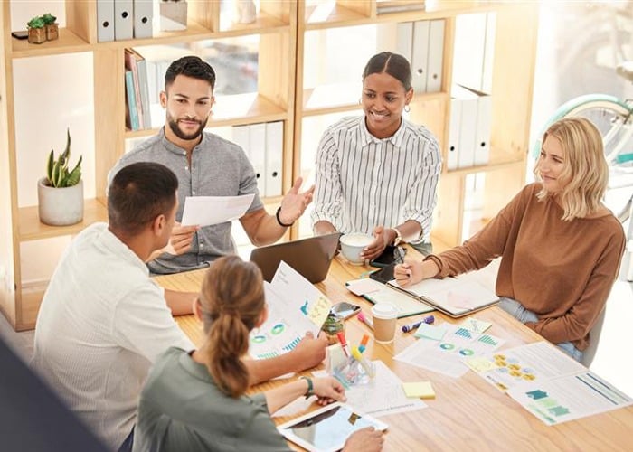 Cross-Functional Team Reviewing Project Deliverables in Office Workspace