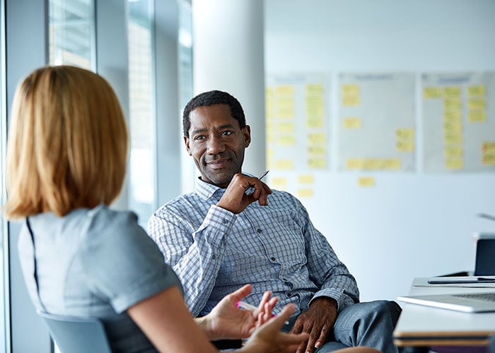 Two Business Professionals Engaged in Strategic Discussion in Modern Corporate Office