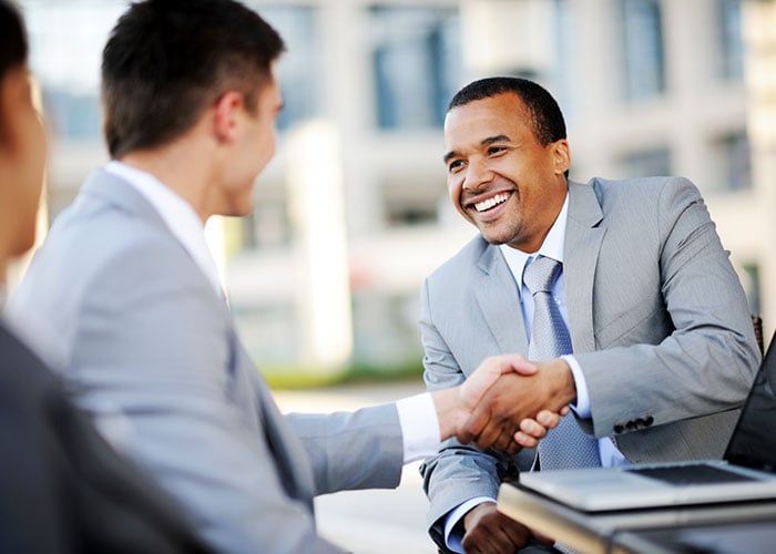 Business Executives Closing Partnership Deal with Handshake at Corporate Meeting