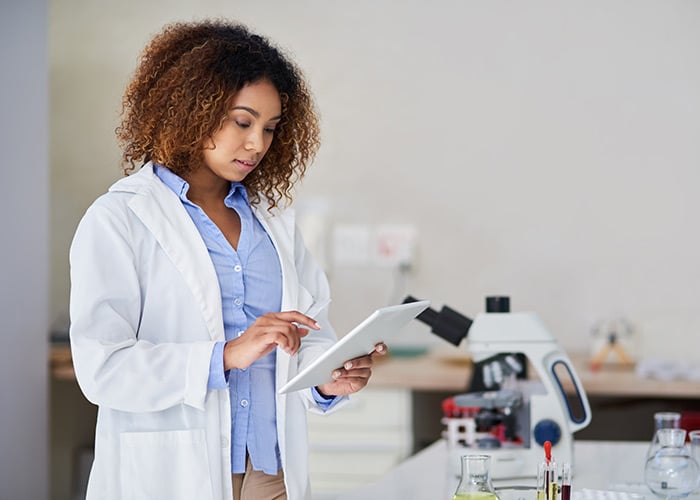 Young woman capturing data on her tablet in the lab